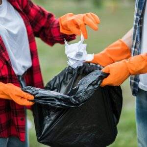 Men and women help each other to collect garbage.